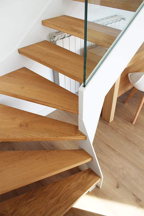 escalera_interior_con_barandilla_de_vidrio_en_vivienda_a_medida.jpg