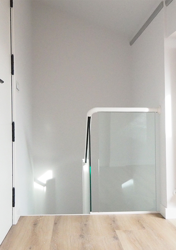 escalera_de_hierro_pintada_en_blanco_con_tramo_de_barandilla_de_vidrio.jpg