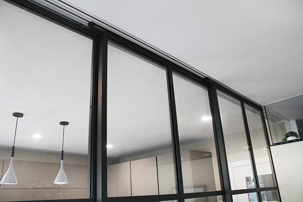 puertas_correderas_de_interiores_estilo_industrial_con_sistema_guiado_sincronizado_en_el_techo.jpg